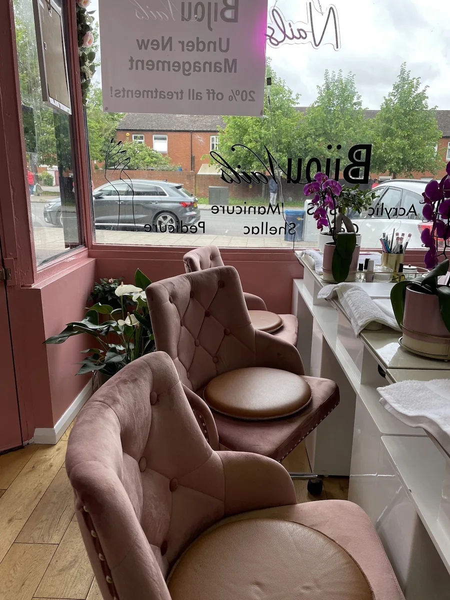 Inside the salon: a pink velvet pedicure chair and fresh flowers by the window