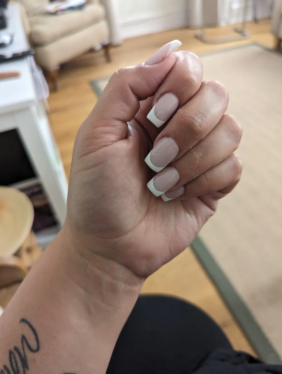 A soft milky white square gel set photographed in the salon
